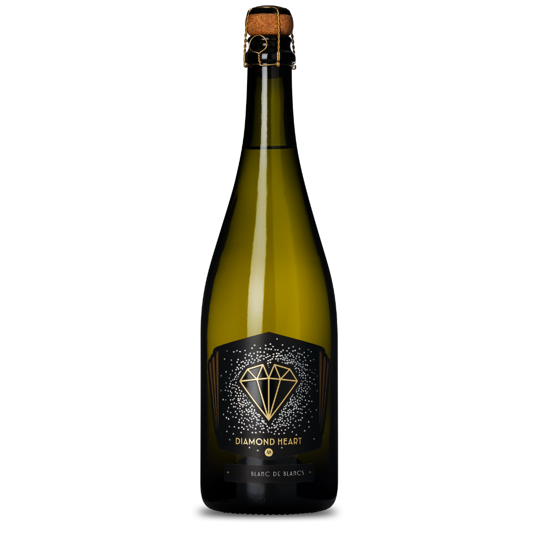 A bottle of DIAMOND HEART BLANC DE BLANCS 2019, featuring a gold diamond logo on an elegant black label. This sophisticated bottle comes with a traditional cork closure enhanced by a secure wire cage.