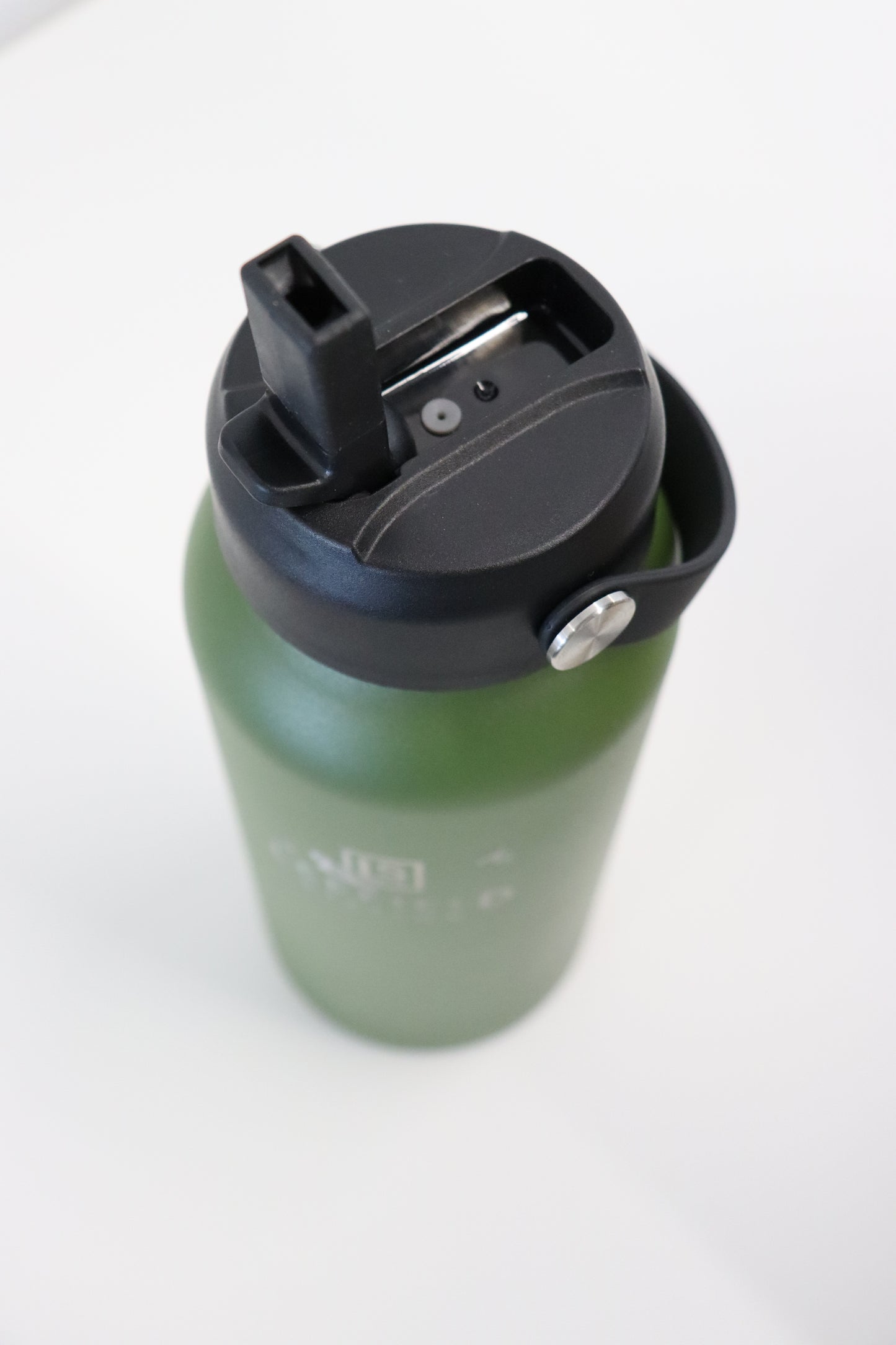The LEEFIELD STATION DRINK BOTTLE by Marisco Family Vineyards is a green, BPA-free reusable water bottle with a black flip-top spout lid. Its straightforward and practical design stands out against a plain white background, assuring safety without sacrificing style.
