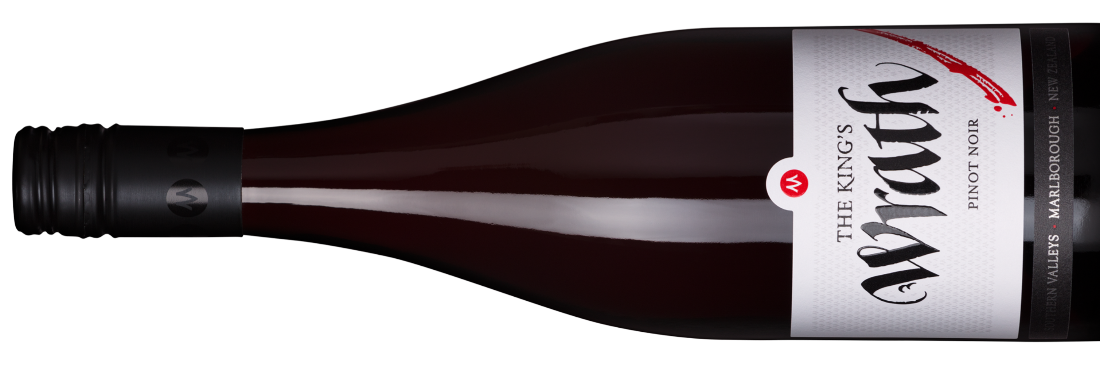 A bottle of The Kings Wrath Pinot Noir lying horizontally. The label is white with black and red text, highlighting The Kings Wrath with red paint splatter. The cap is black with a red and white logo. .